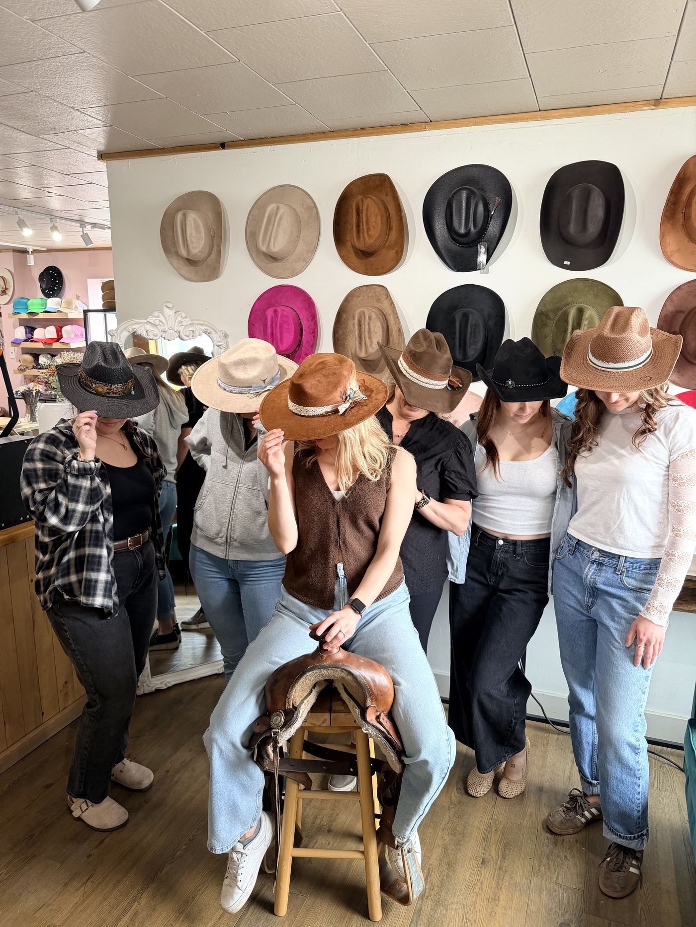 Group playfully tipping their hats over their faces at a birthday party