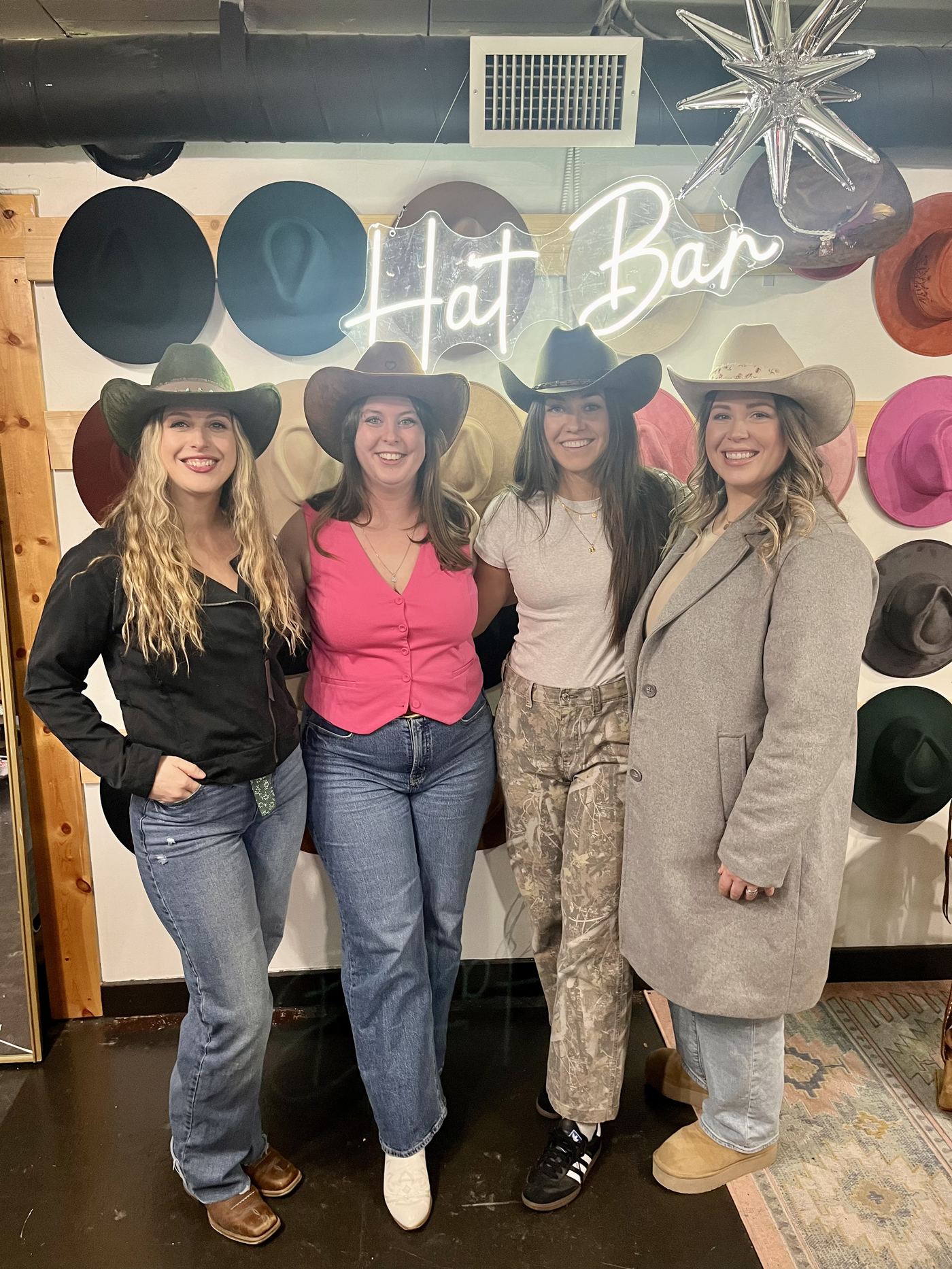 Group posing under the Hat Bar neon sign at a Saddle N Spurs birthday party
