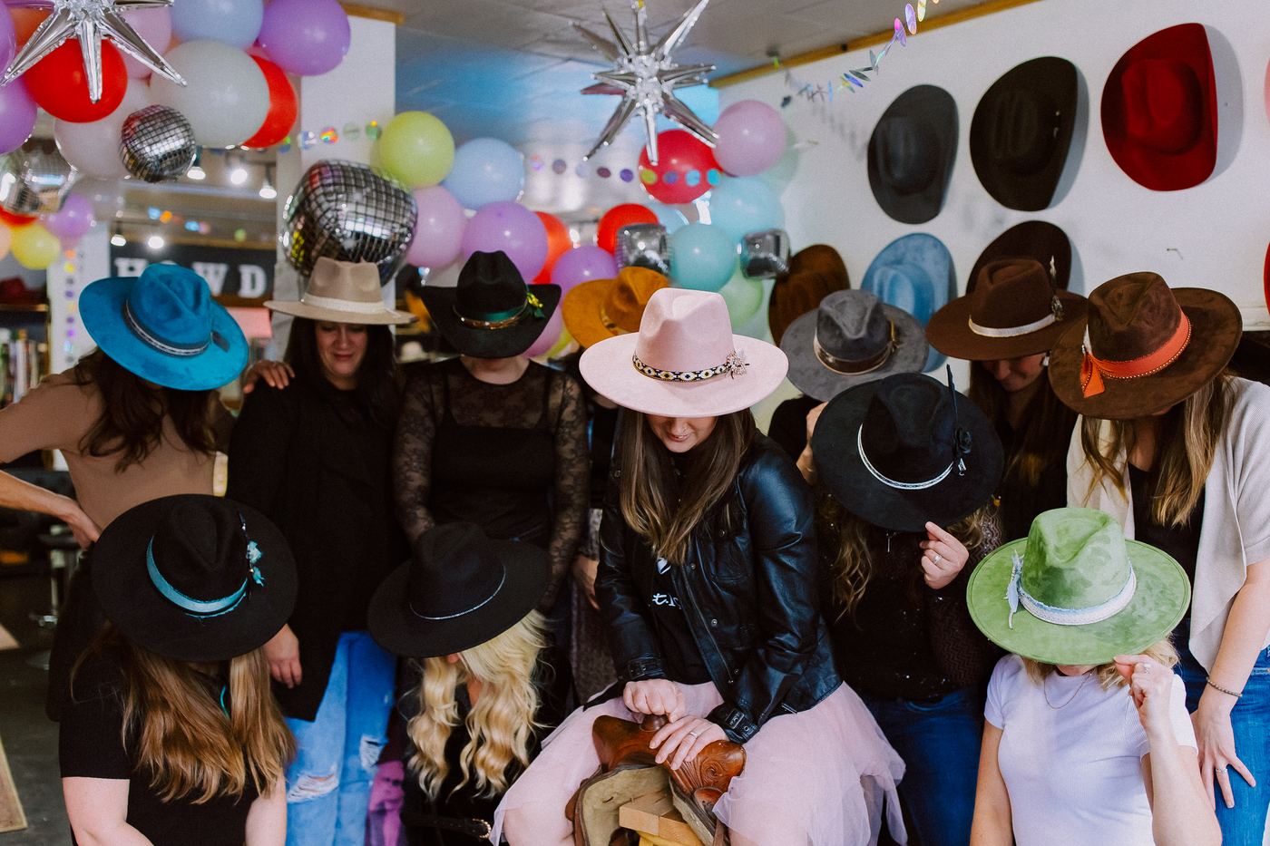 Group celebrating a birthday party at Saddle N Spurs, decorated with balloons and disco balls