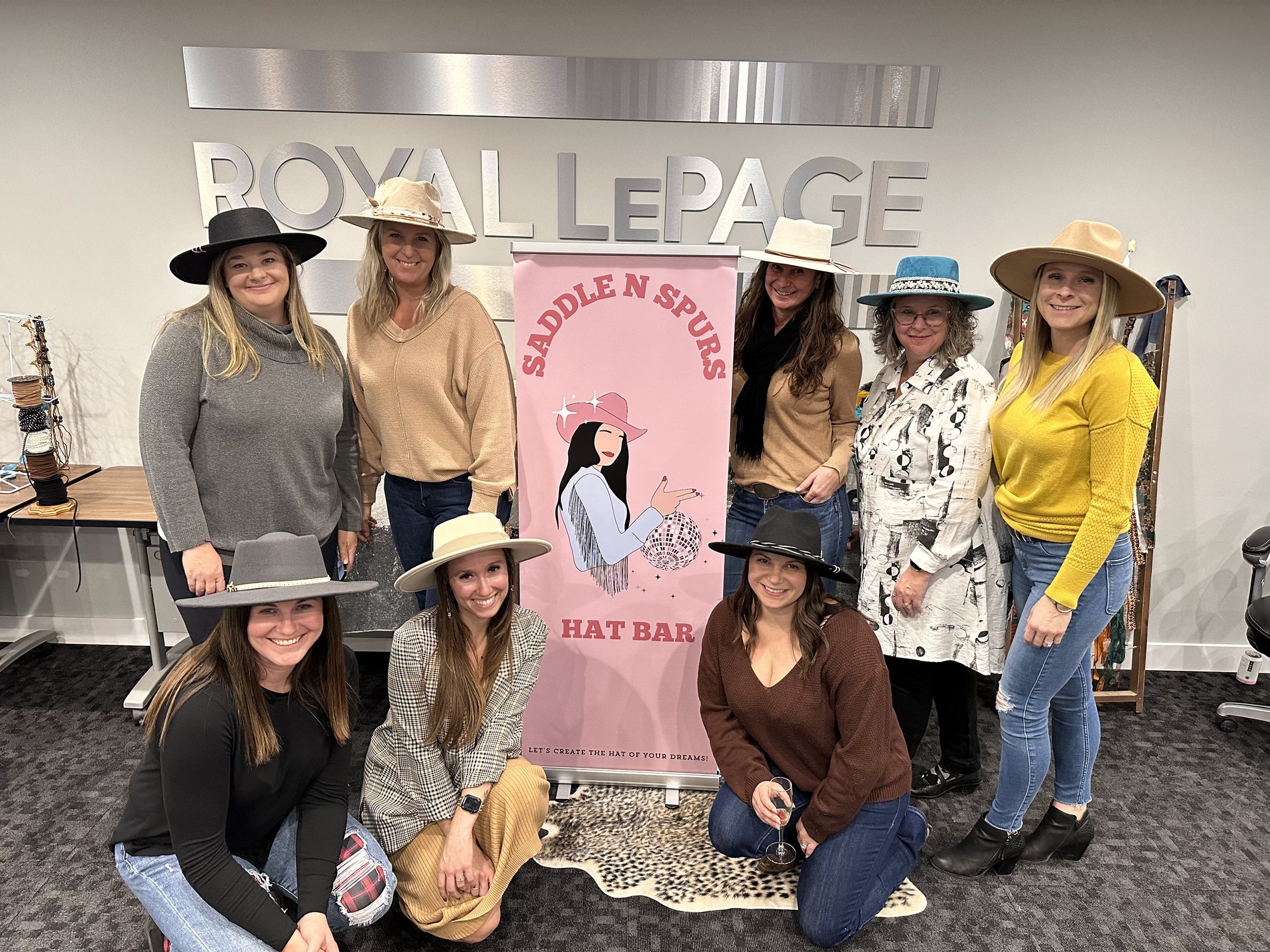 Royal LePage Kamloops team wearing custom hats at an in-office hat bar event