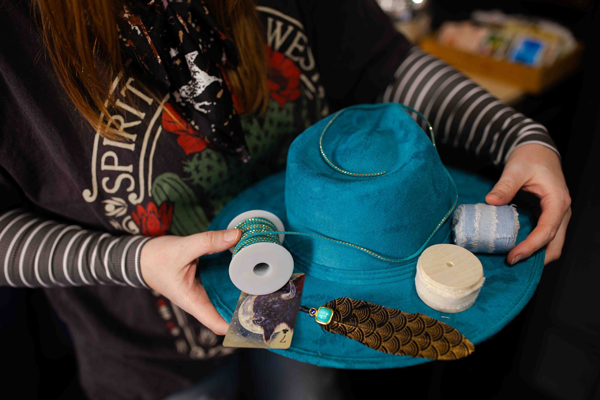 Stylist adding a band to a custom hat