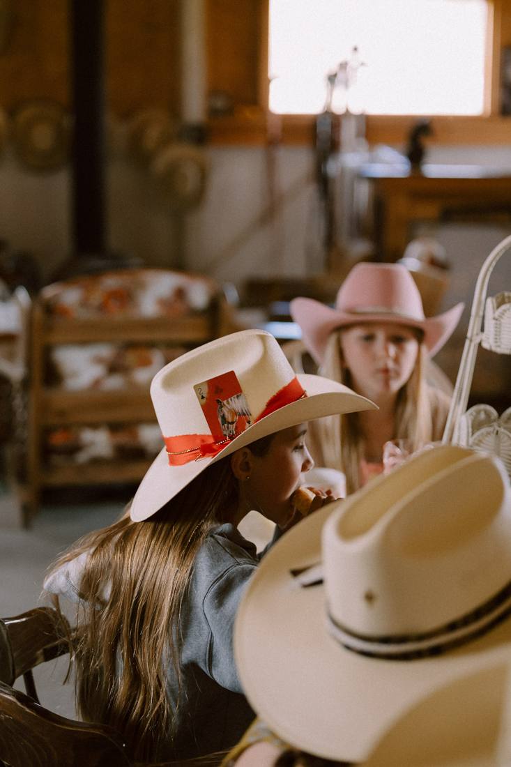 Group of girls wearing their custom hats in the barn