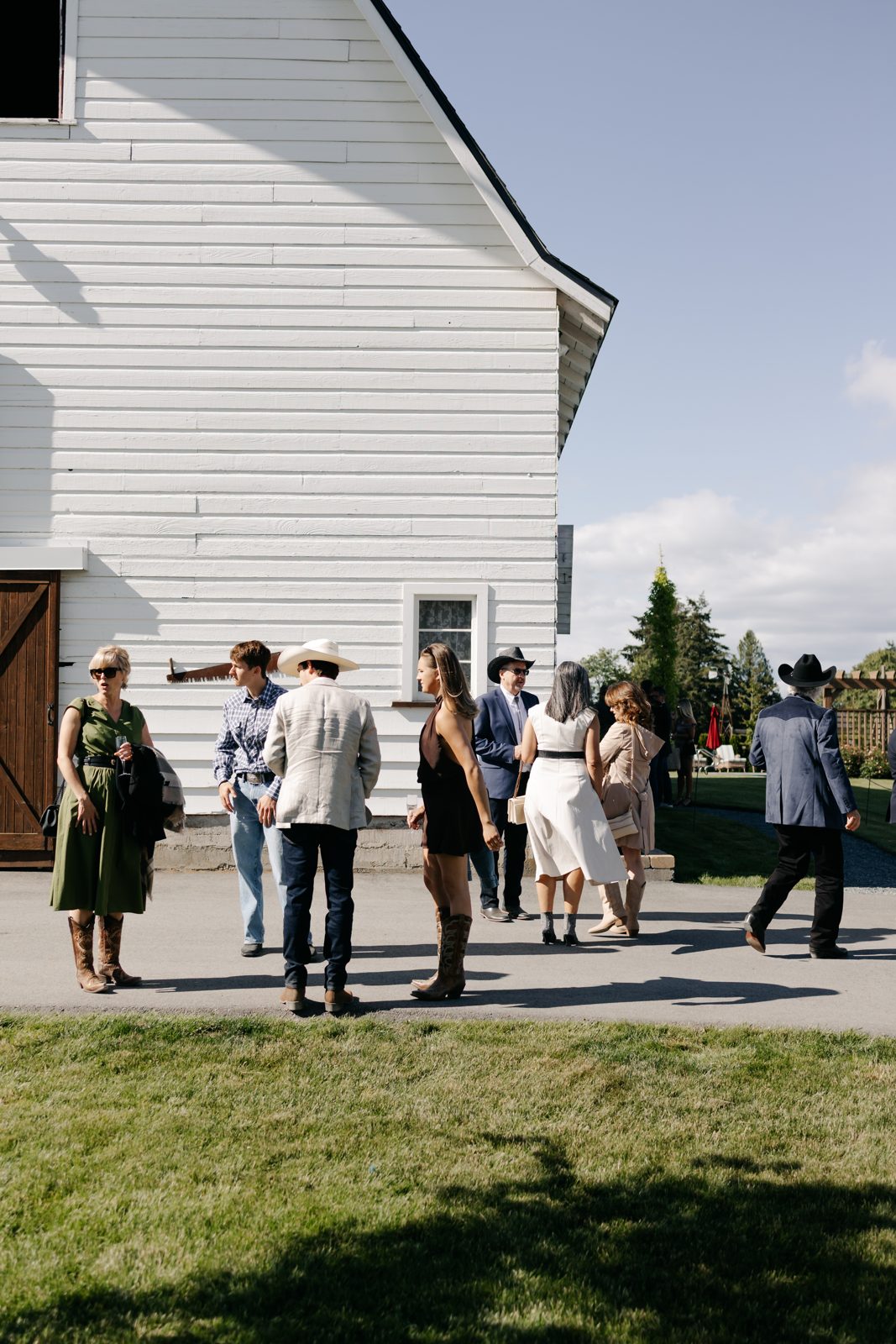 Guests mingling outside a barn wedding venue