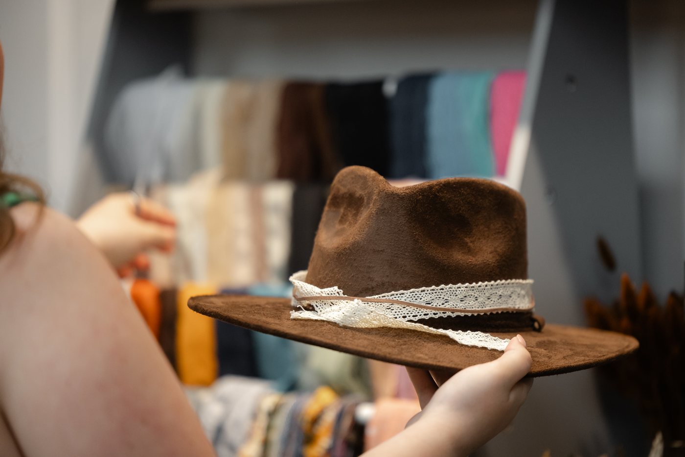 Custom hat with lace trim in front of the ribbon wall at Saddle N Spurs Kelowna