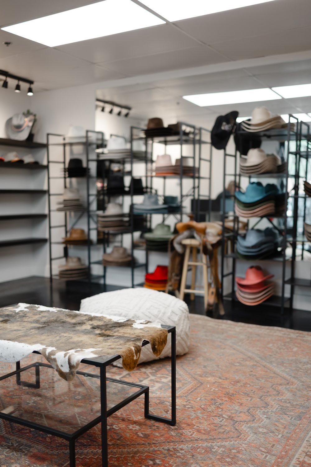 Seating area and hat wall inside the Saddle N Spurs Kelowna storefront