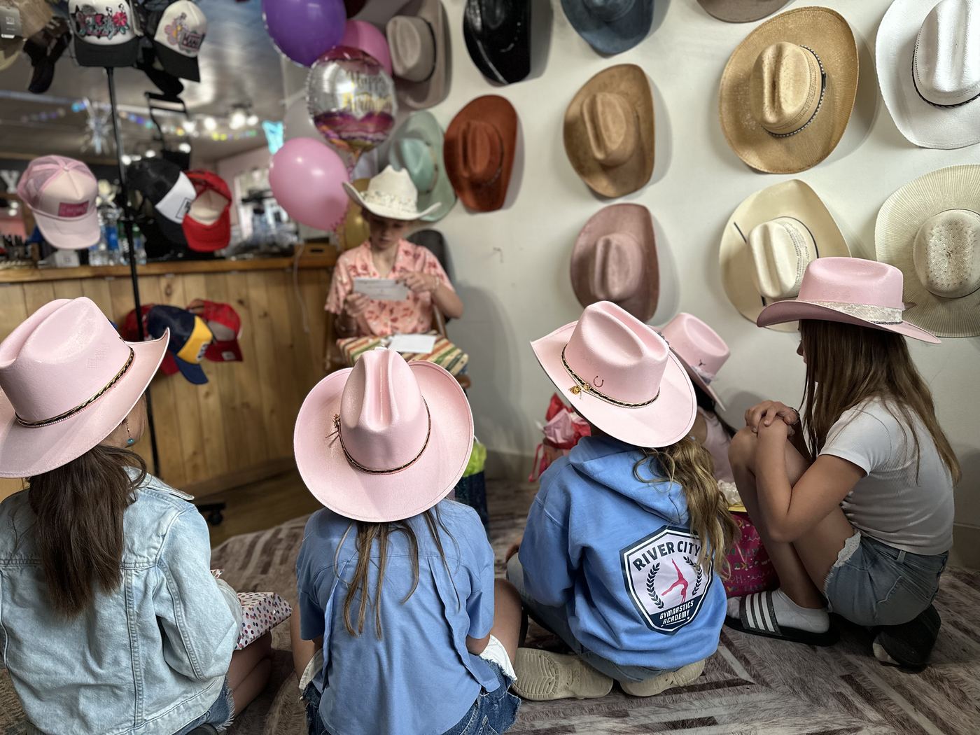Kids in pink cowboy hats gathered for a birthday celebration at Saddle N Spurs