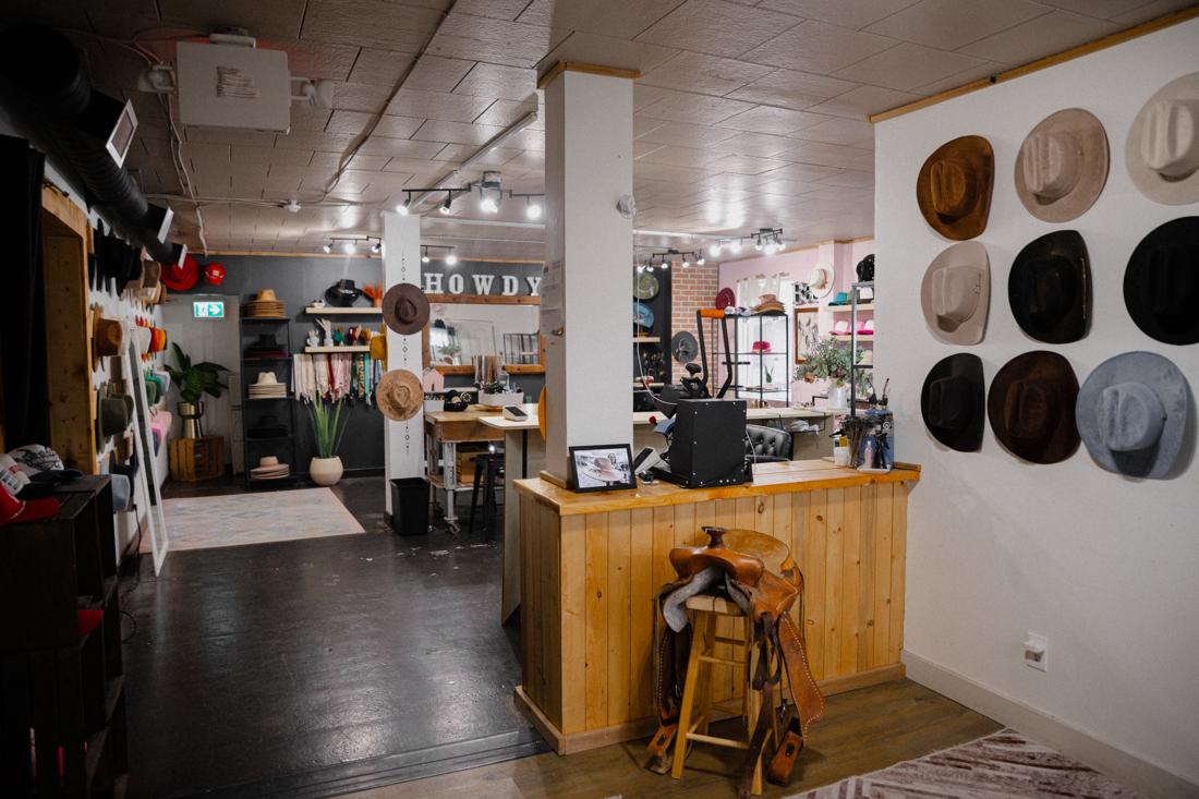 Inside the Saddle N Spurs shop — HOWDY sign, hat wall, and saddle display