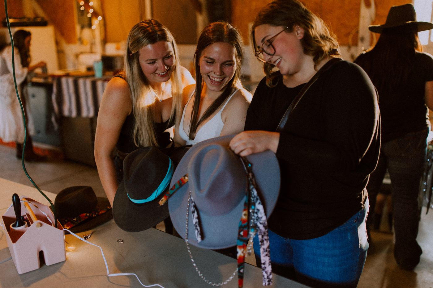 Guests laughing together while styling hats at the Erin Valley hat bar