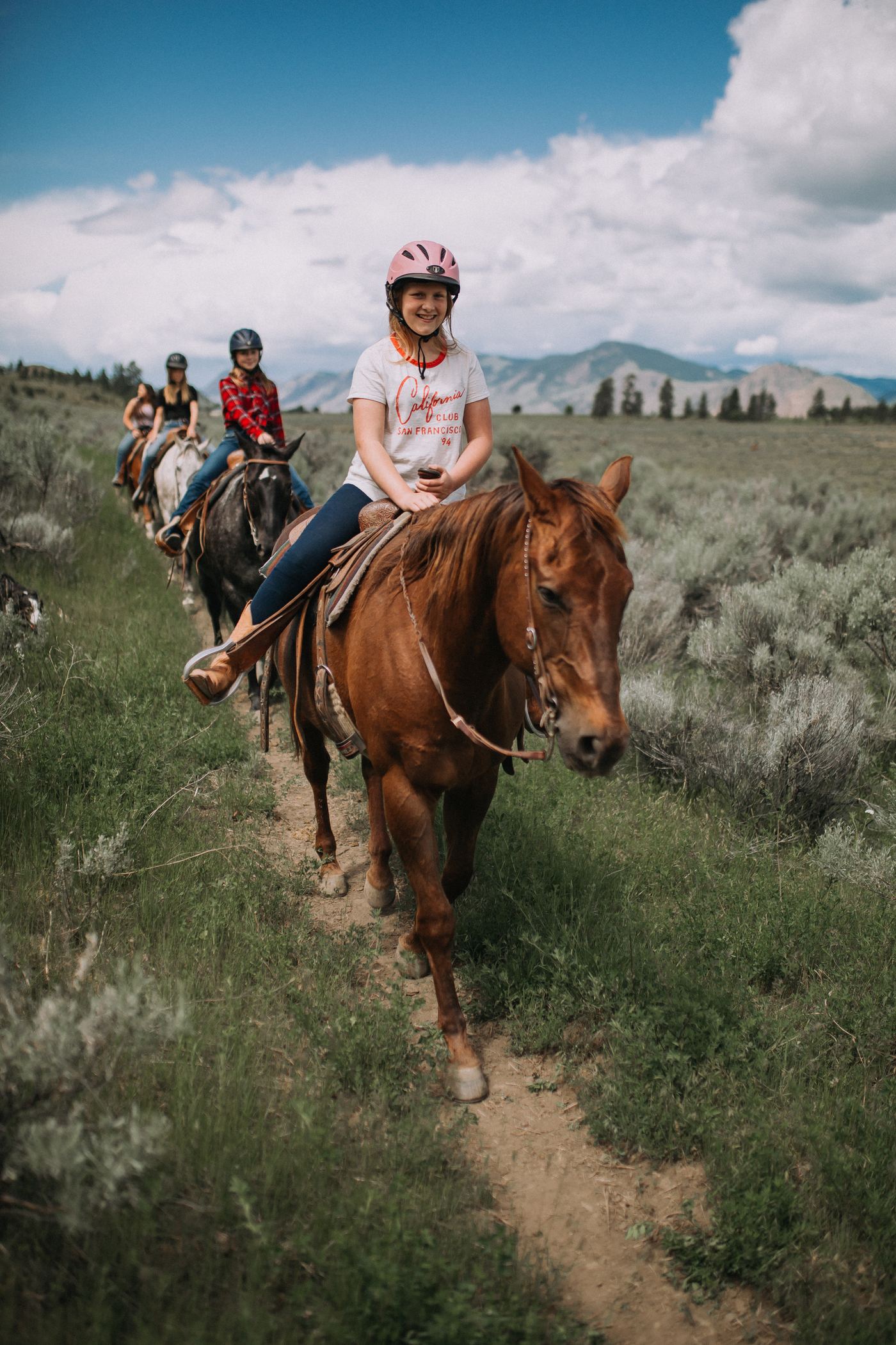 Young rider smiling on horseback along the trail at Erin Valley Riding Stables