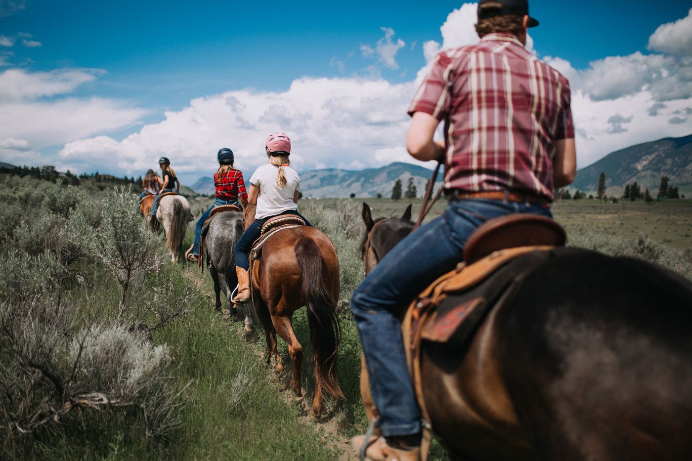Close-up of riders on horseback single file along the trail at Erin Valley